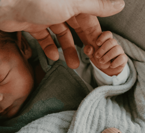 bébé qui tient le doigt du parent - Mustela France - 1